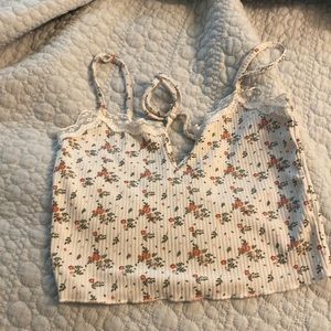 The brand of this cute crop top is POOF New York. The size is a small.